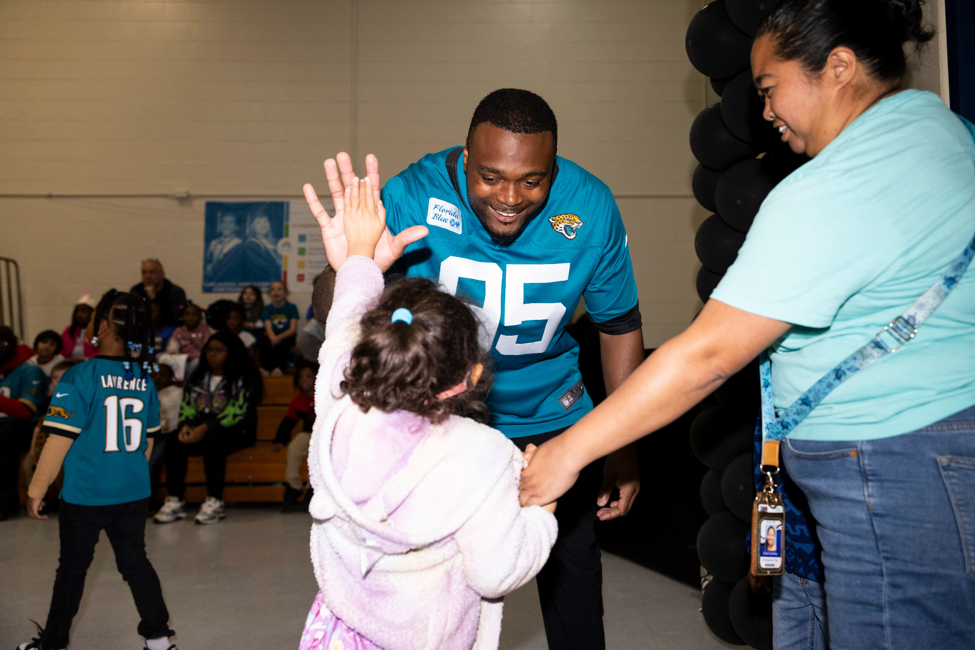 BJ Green high-fiving a young child at a school visit